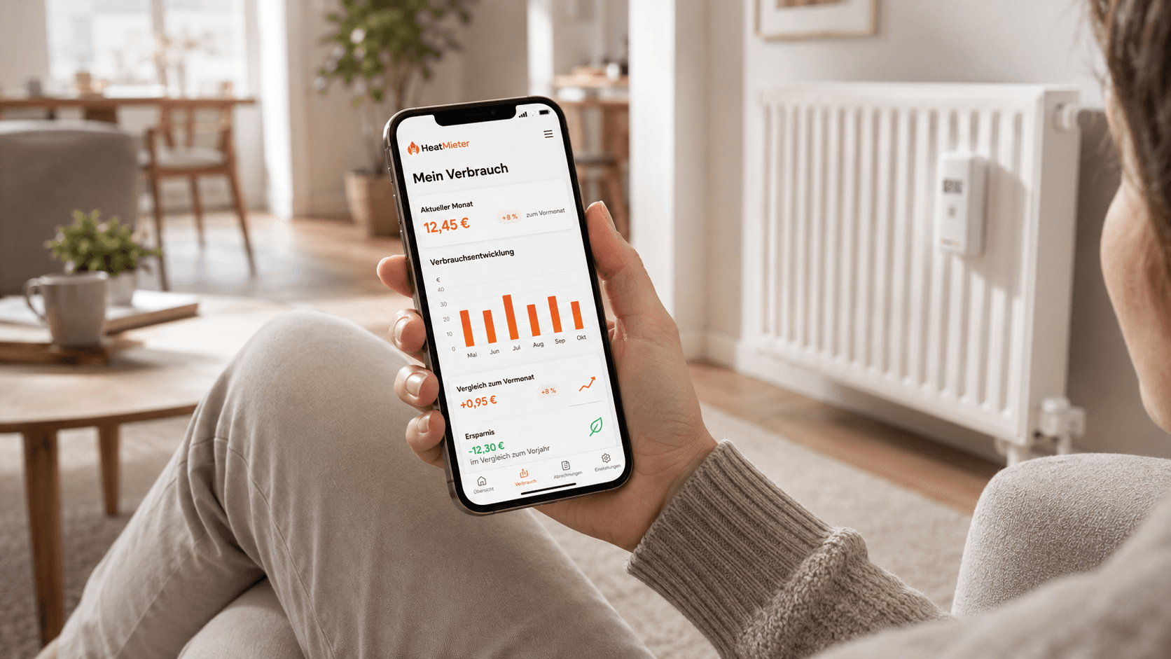 Mieter nutzt die HeatMieter Smartphone-App entspannt im Wohnzimmer und sieht seinen aktuellen Verbrauch